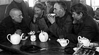 Travellers at a railway station taking a meal of t