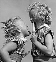 Two sisters licking ice lollies on the beach at Bo