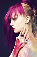A young woman with a pink hair piece and a dusting