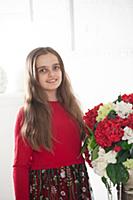 Девочка позирует в студии с букетом цветов