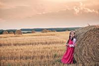 Девочка в русской народной одежде у стога сена