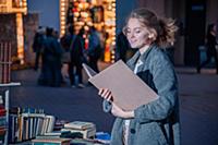 Девушка в сером пальто с книгой в руках на улице г
